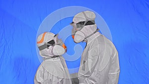 Doctor man and woman in protective costume suit, gas protect medical spray paint mask. Love couple kiss and hug, health