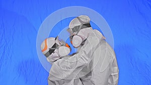 Doctor man and woman in protective costume suit, gas protect medical spray paint mask. Love couple kiss and hug, health