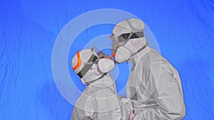 Doctor man and woman in protective costume suit, gas protect medical spray paint mask. Love couple kiss and hug, health