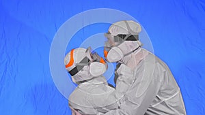 Doctor man and woman in protective costume suit, gas protect medical spray paint mask. Love couple kiss and hug, health