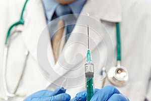 Doctor in mask holding a medical injection syringe