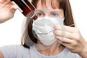 Doctor in mask holding medicine syrup