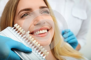 Doctor matching patient`s teeth color with palette