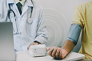 Doctor measures the blood pressure of an elderly male patient