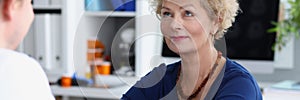 Doctor measures blood pressure of an elderly woman in medical office