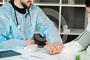 Doctor measures the pressure of the patient in the clinic