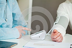 Doctor measures the pressure of the patient in clinic.