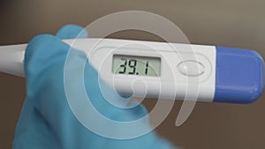 The doctor measures the temperature in a patient with a coronavirus patient. Close-up electronic thermometer