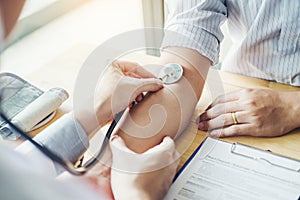 Doctor Measuring arterial blood pressure man patient on arm Health care in hospital