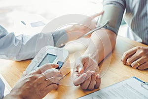 Doctor Measuring arterial blood pressure with man patient on arm Health care in hospital