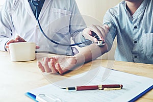 Doctor Measuring arterial blood pressure woman patient on arm He