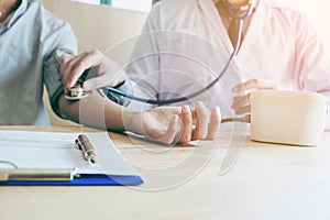 Doctor Measuring arterial blood pressure woman patient on right