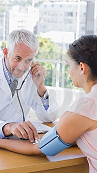 Doctor measuring the blood pressure of his patient