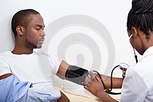 Doctor Measuring Blood Pressure Of Patient