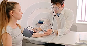 Doctor measuring blood pressure of patient.