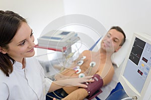 Doctor measuring blood pressure patient with electrodes