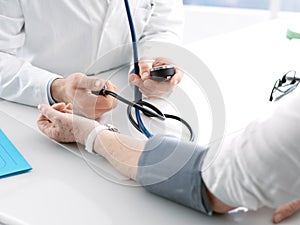 Doctor measuring blood pressure of a senior patient