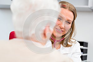 Doctor measuring blood pressure of senior patient