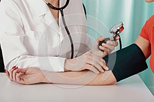 Doctor measuring blood pressure of young patient in medical clinic