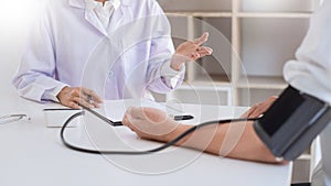 Doctor measuring and checking blood pressure of patient in hospital, Health care and medicine concept