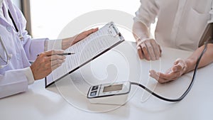 Doctor measuring and checking blood pressure of patient in hospital, Health care and medicine concept