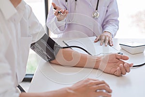 Doctor measuring and checking blood pressure of patient in hospital, Health care and medicine concept