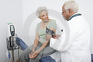 Doctor Measuring Patient's Blood Pressure At Clinic