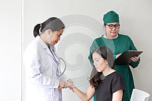 The doctor is measuring the patient`s pulse. Female medical doct