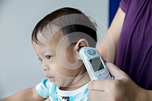 Doctor measuring temperature cute baby boy at hospital .