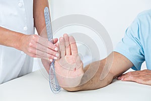 Doctor measuring wrist with goniometer