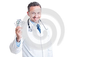 Doctor or medic holding and showing pill tablets
