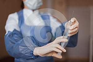 Doctor in medical gloves hold a syringe with an antibiotic. A nurse prepares to give an injection. Close-up.
