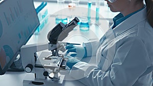 Doctor in medical laboratory directs important investigations. Its sophisticated scientific methods under microscope and