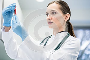 Doctor in medical laboratory looking at blood test