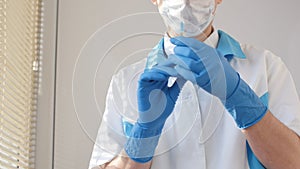 Doctor in medical mask and blue gloves preparing to injection.