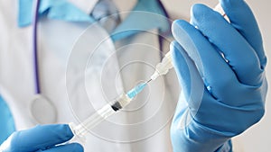 Doctor in medical mask and blue gloves preparing to injection.