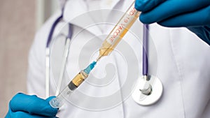 Doctor in medical mask and blue gloves preparing to injection.