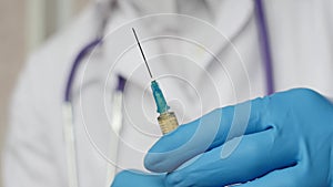 Doctor in medical mask and blue gloves preparing to injection.