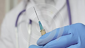 Doctor in medical mask and blue gloves preparing to injection.