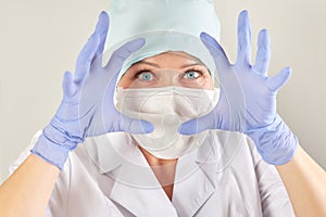 Doctor in a medical mask and blue gloves scares the patient