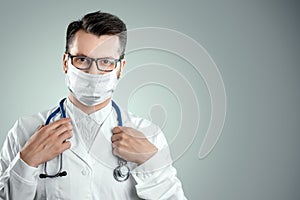Doctor in a medical mask on a light background. The concept of a ban on leaving the house, self-isolation, quarantine, precautions
