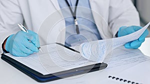 Doctor, medical professional or scientist writing a report, signing documents or taking notes while working in a science