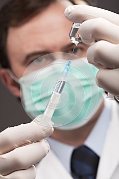 Doctor with medical syringe in hands