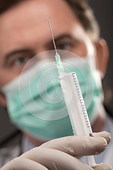 Doctor with medical syringe in hands