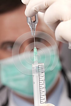 Doctor with medical syringe in hands