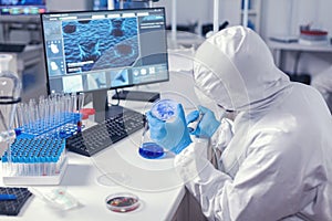 Doctor in medicine lab engineering virus on petri dish