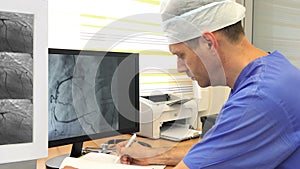 Doctor at monitor with coronary angiography