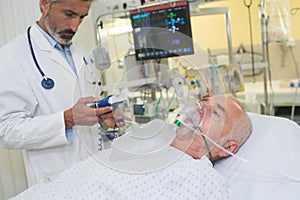 Doctor monitoring patient wearing oxygen mask