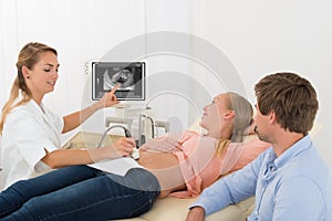 Doctor Moving Ultrasound Transducer On Pregnant Woman`s Belly