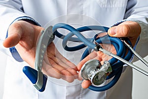 Doctor neurologist with neurological rubber reflex hammer and stethoscope in hand. Photos for visualizing process of diagnostics o